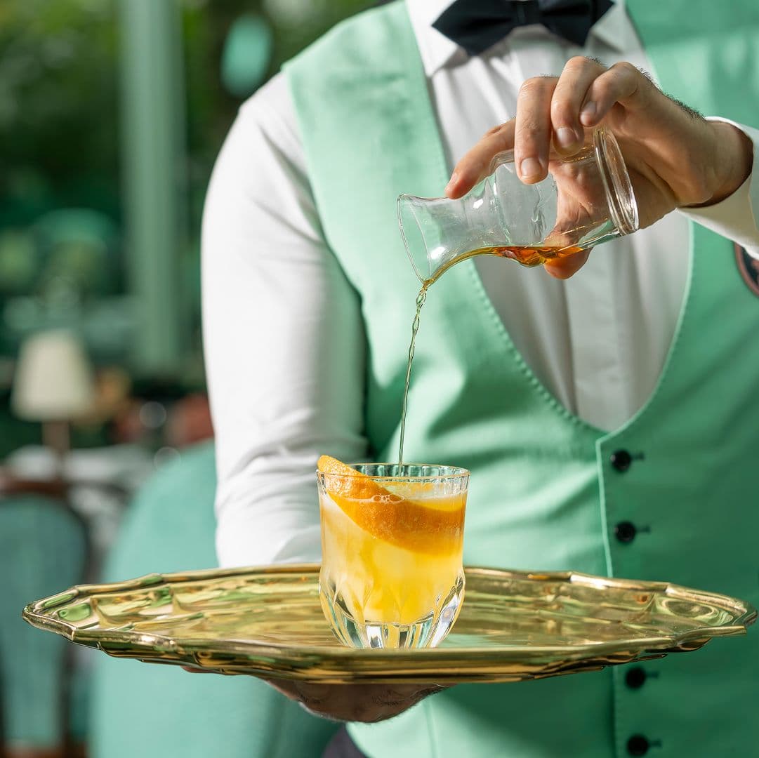 Mixologist pouring cocktail